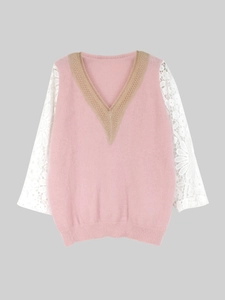 Detailed close-up of delicate beige floral lace neckline and pink knit fabric texture