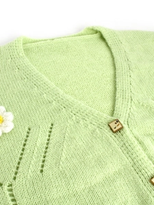 Pale green V-neck knitted cardigan with delicate hollow patterns and a crochet flower