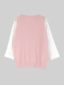 Detail of pink knit top featuring white floral lace sleeves and delicate stitching