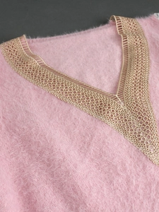 Close-up of pink fuzzy knit sweater featuring delicate golden lace V-neck embroidery