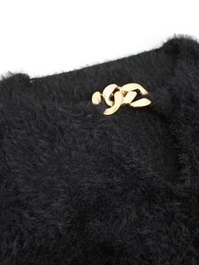 Close-up of black fuzzy knit sweater featuring a stylish gold metal chain link V-neckline