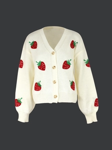 Detailed view of knitted cardigan with strawberry embroidery and amber-textured buttons