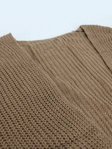 Detail shot of brown knit cardigan showing thick ribbed texture and cable knit patterns