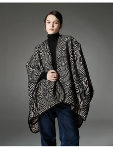 Dettaglio di un poncho in maglia con elegante motivo zebrato bianco e nero per l'autunno