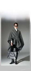 Close-up of black and white striped knit shawl with stylish buckle and knot detail