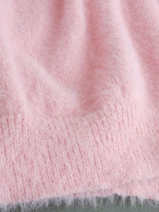 Close-up of soft pink mohair lace sweater fabric showing fuzzy knit texture details