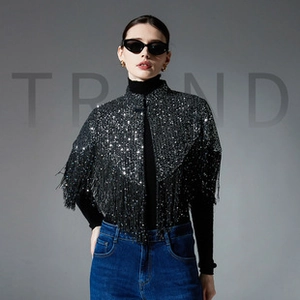 Detail of black sequin cape with fringe hem and shimmering texture for women