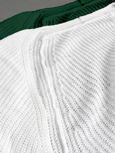 Detailed macro view of two-tone cable knit fabric in white and dark green colors