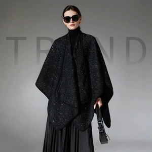 Detail of black knitted shawl with white speckled texture and clean-edged trim