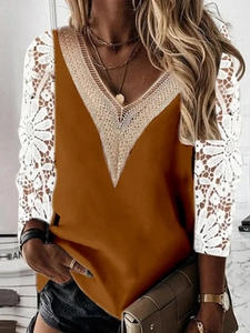 Detailed view of amber brown long sleeve top with white lace patchwork and V-neckline