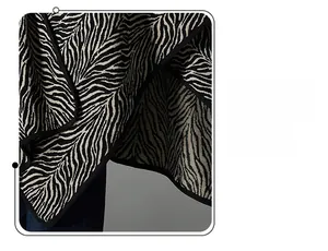 Detail shot of the knit zebra pattern shawl showing high-quality black hemmed edge finishing