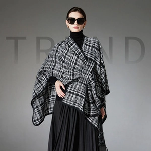 Detail view of thickened black and white plaid cape coat with premium tweed texture