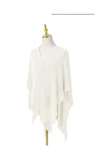 Détail d'un châle en tricot blanc avec texture en maille ajourée et longues franges