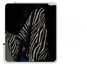 Detail of zebra pattern knit fabric with black faux fur trim on a winter shawl