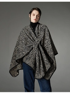Detailed close-up of a knit zebra pattern shawl with refined black hem and wrap-style design
