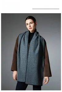 Detail of gray-blue winter scarf with black stitching on elegant cashmere blend fabric
