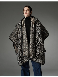Détail du poncho à capuche en tricot à motif zébré avec tissu épais et bordure noire
