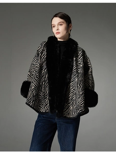 Detail view of zebra pattern shawl with luxurious black faux fur trim on sleeves