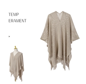 Détail d'un châle en maille ajourée avec des franges élégantes et un col en V minimaliste