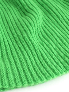 Detail of bright green turtleneck sweater showing ribbed knit texture and cable stitching