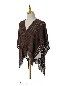 Détail d'un châle en tricot marron café avec des franges et des motifs géométriques