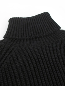Detailaufnahme eines schwarzen Rollkragenpullovers mit Grobstrick-Rippen und Raglanärmeln