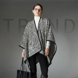 Detail of wool blend cape featuring sparkling sequins and black fabric piping trim