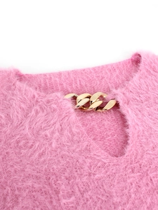 Detail of pink fuzzy knit sweater showing teardrop cutout and chunky gold chain collar