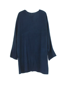 Detail of dark blue knit sweater showing loose fit sleeves and ribbed texture cuffs