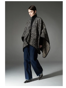 Dettaglio della mantella poncho con cappuccio zebrato, bordo a contrasto e linea morbida