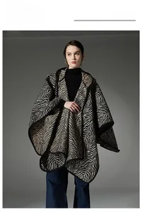 Détail du poncho en maille à motif zèbre avec bordure noire et texture épaisse de luxe