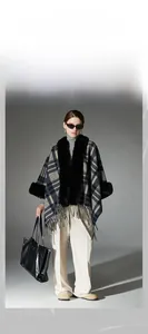 Detail of navy blue plaid shawl featuring a faux fur collar and long fringe trim