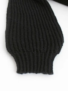 Detailaufnahme der schwarzen Pullover-Manschette mit dicker Rippstrick-Textur