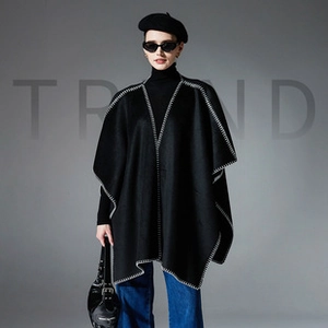 Detail view of the hand-stitched white contrast seams on this black woolen cape shawl