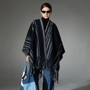 Close-up of thick navy blue wool blend shawl featuring white geometric patterns and fringe detail