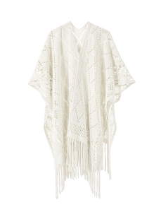 Vue détaillée du châle en maille crème avec franges délicates et motifs ajourés