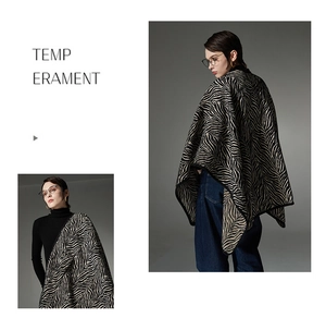 Detailed close-up showing the zebra pattern texture on thick knitted winter shawl cape