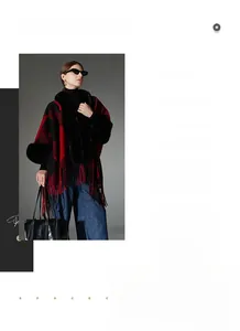 Detail of red and black plaid poncho featuring faux fur collar and fringe hemline