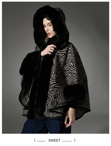 Dettaglio del poncho con motivo zebra e bordo in lussuosa ecopelliccia nera per l'inverno