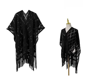 Détail du châle noir en maille crochetée ajourée avec motifs losanges et longues franges