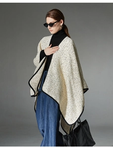 Close-up of beige tweed wool shawl featuring premium black contrast trim and woven texture