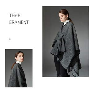 Detail view of women's black and white striped knit poncho with asymmetric hem and buckle
