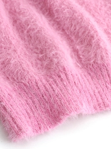 Close-up of soft pink mohair knit texture with ribbed hem detail on women sweater
