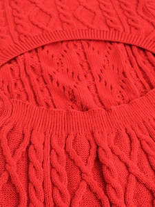 Close-up of vibrant red cable knit texture and crew neck detail on women's knit dress