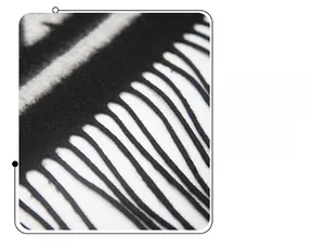 Macro shot of black and white houndstooth wool shawl featuring detailed fringe tassels