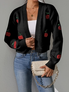 Detail of black knitted cardigan with red cherry embroidery and gold chain quilted bag