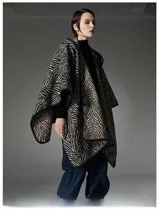 Vue détaillée d'un poncho en tricot à motif zébré noir et blanc avec bordure noire élégante