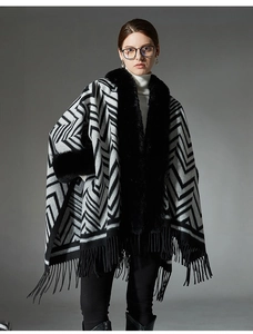 Détail de châle en tricot gris à motifs géométriques, col en fourrure et franges noires