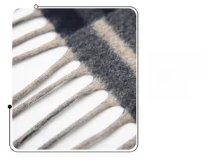Close-up of the elegant plaid pattern and soft tassel fringes on the woven shawl