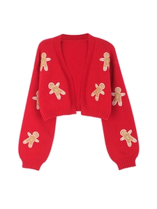 Detail of red knitted cardigan featuring festive gingerbread man patches and ribbed cuffs